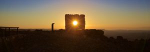 Sunrise through hole in square stone statue